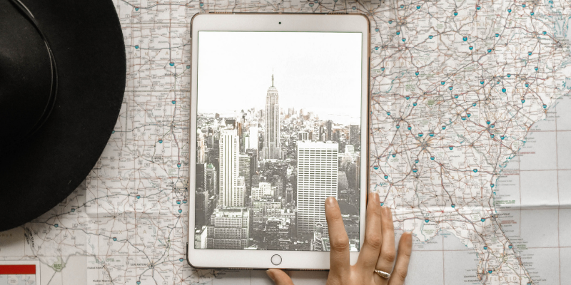 Map with a tablet on it with a bird eye's image of a city (assumably the city on the map)